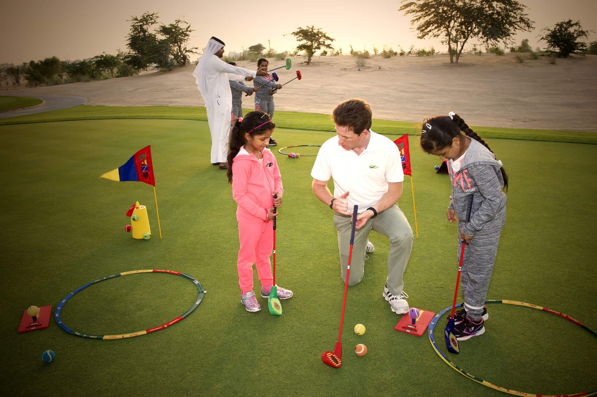 Mohammed Al Naimi and Rhys Beecher teaching the youngsters on the practice putting green.