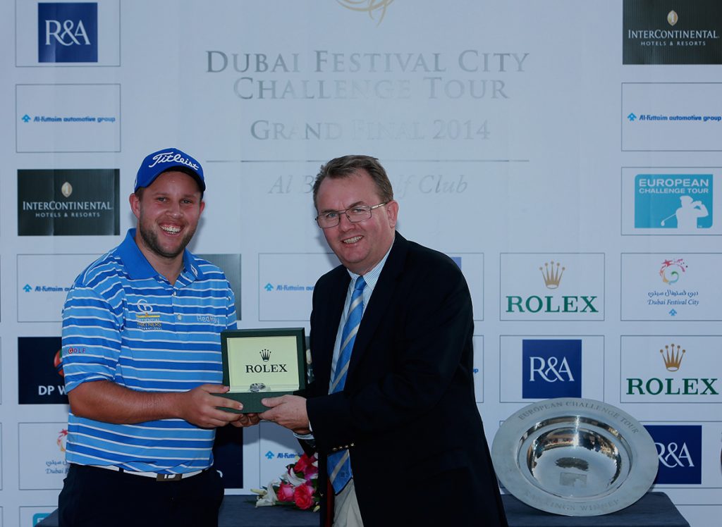 DUBAI, UNITED ARAB EMIRATES - NOVEMBER 08: Andrew Johnson of England is awarded with a Rolex time piece by Nick Tarratt, European Tour, International Director after winning the Challenge Tour Rankings after the final round of the Dubai Festival City Challenge Tour Grand Final at Al Badia Golf Club on November 8, 2014 in Dubai, United Arab Emirates. (Photo by Warren Little/Getty Images)